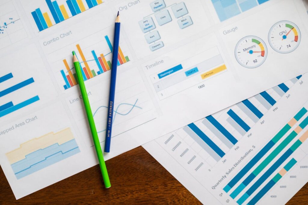 pexels photo 7948063 Flat lay of various business charts and colored pencils on wooden table, highlighting financial analysis.